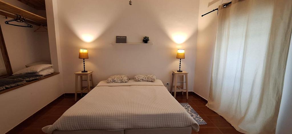 two beds in a room with two lamps at Daniel in Lagoa