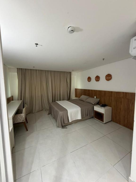 ein Schlafzimmer mit einem Bett und einem Schreibtisch in der Unterkunft Flat em Palmas no Vivence hotel in Palmas
