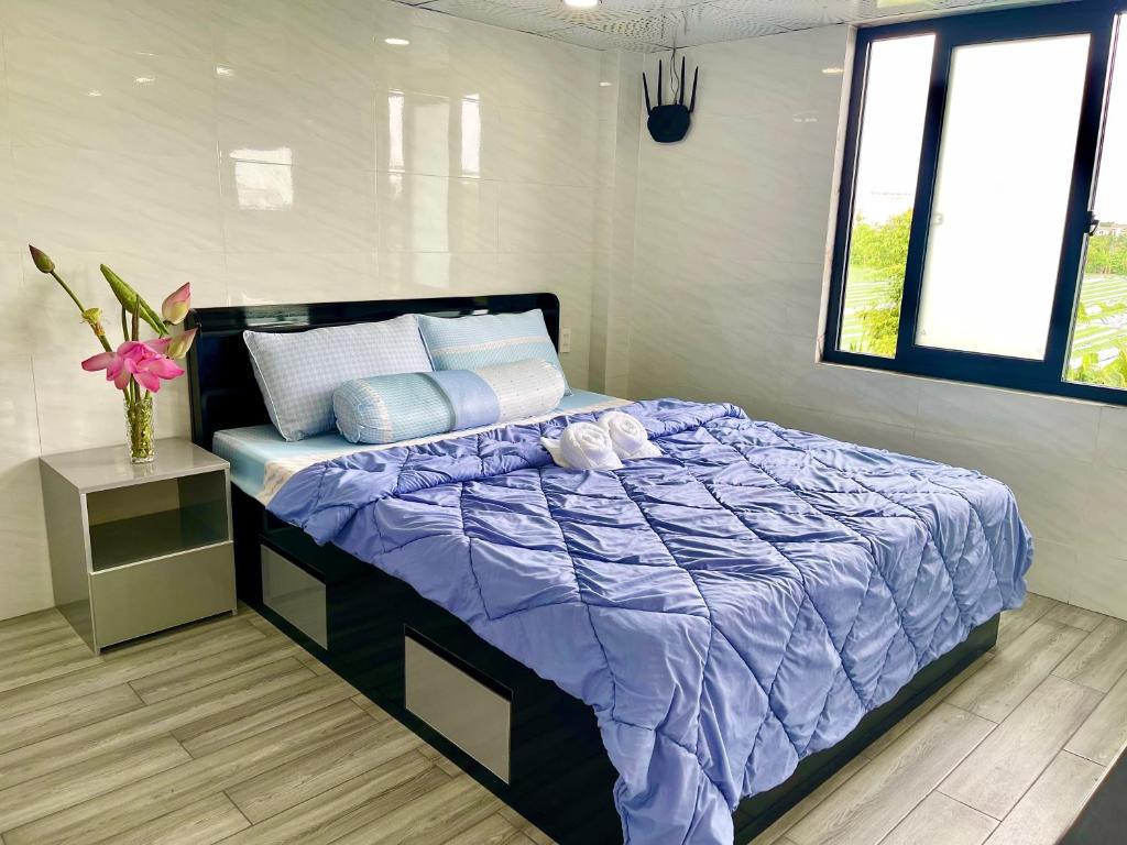a bedroom with a purple bed and a window at Homestay Phương Chi in Ấp Mỹ Phước