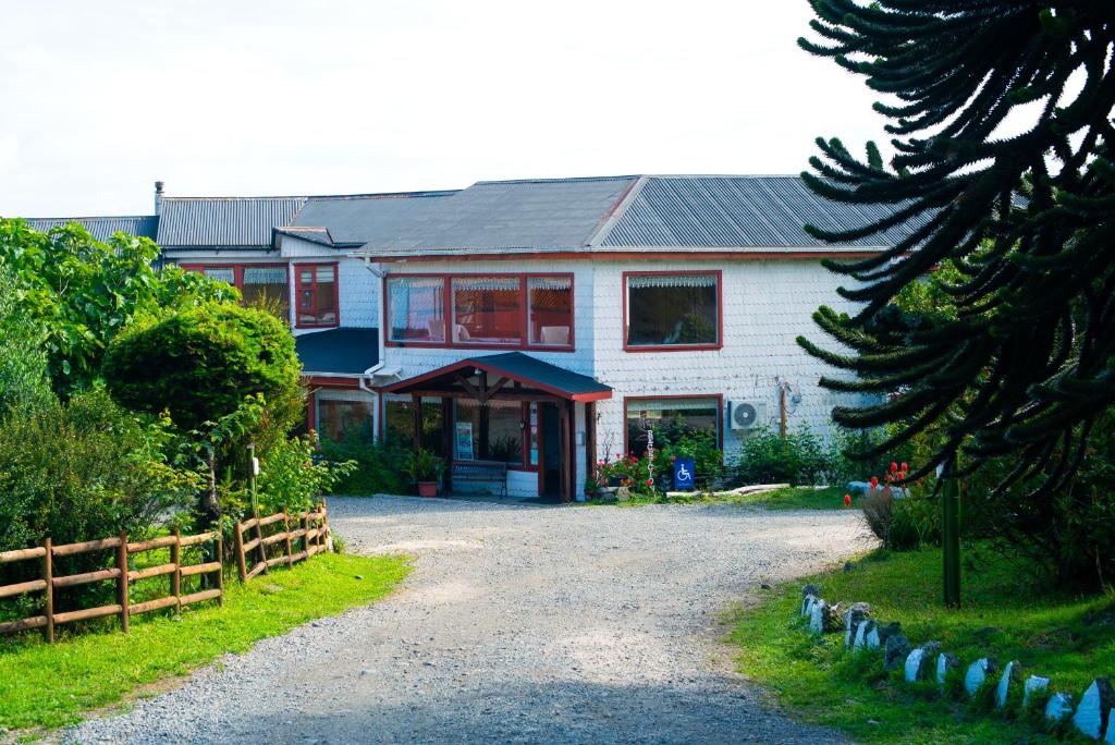 a large white house with a fence in front of it at Complejo Turistico Arena Gruesa in Ancud