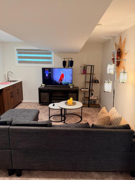 a living room with a couch and a tv at Cozy and Stylish Private Basement Suite in Winnipeg