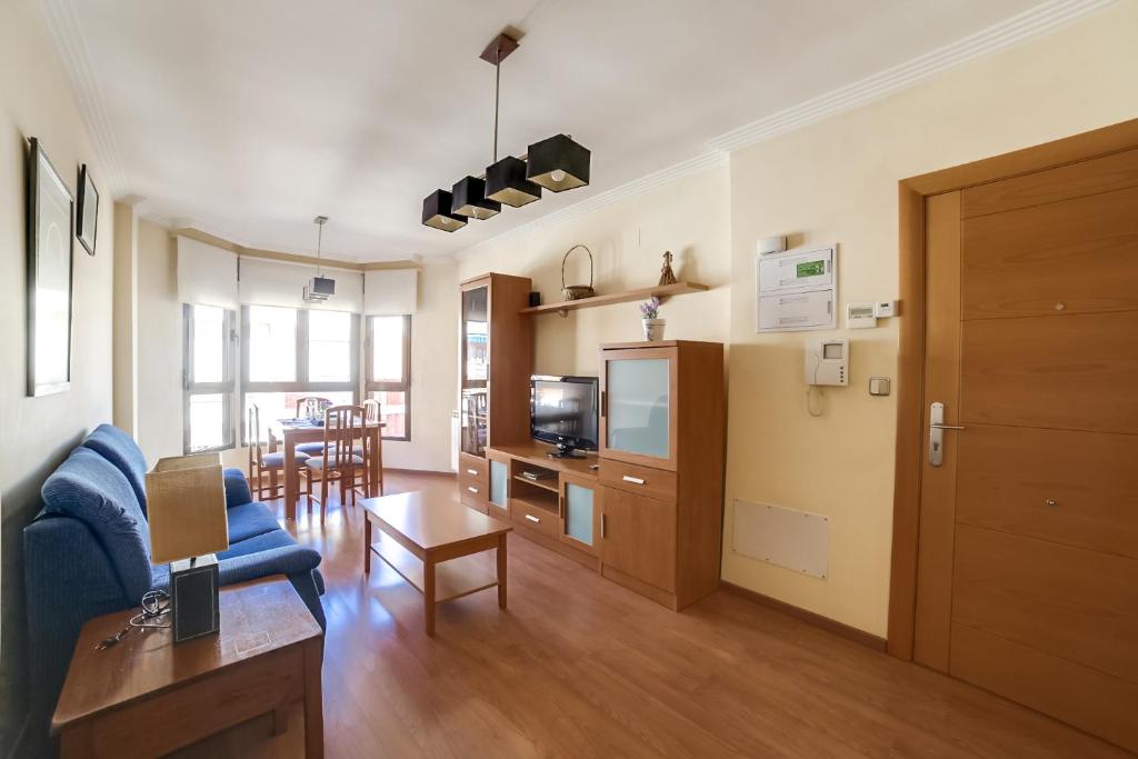 a living room with a blue couch and a table at Apartamentos Legazpi in Albacete