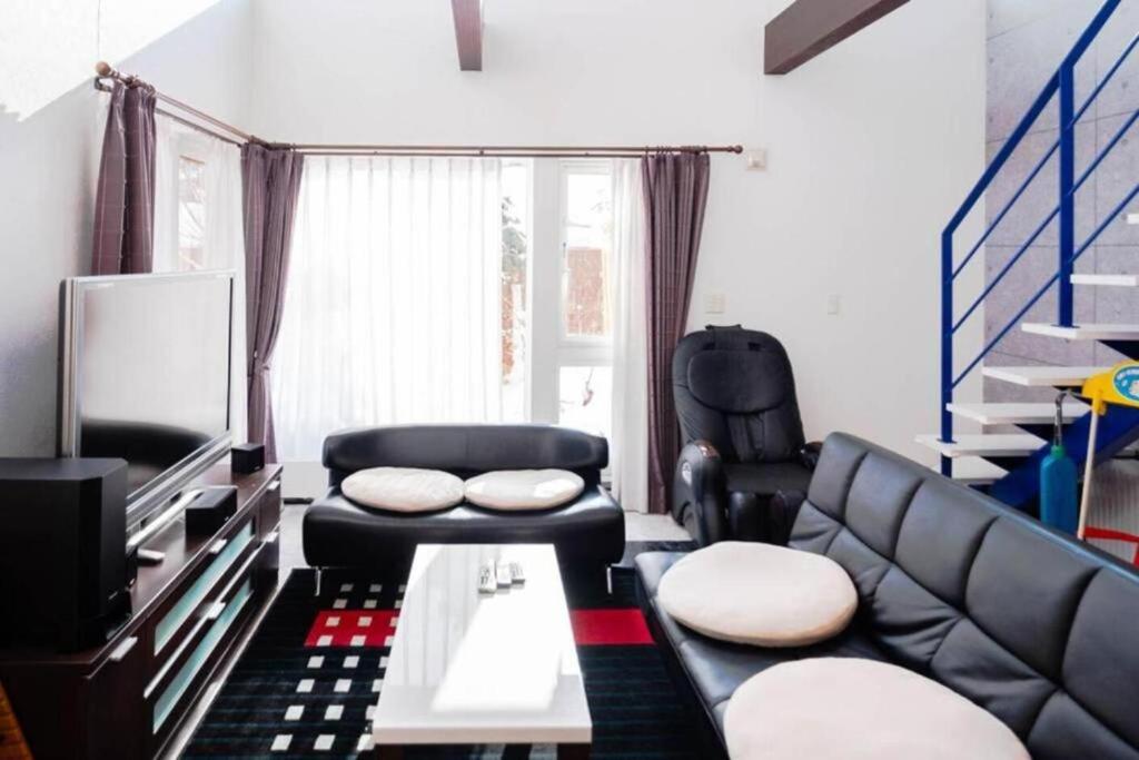 a living room with a couch and a chair at STAY IN TOYOOKA in Asahikawa