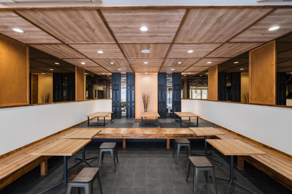 ein großer Konferenzraum mit Holztischen und Stühlen in der Unterkunft OKINI - Doyanen Hotels in Osaka