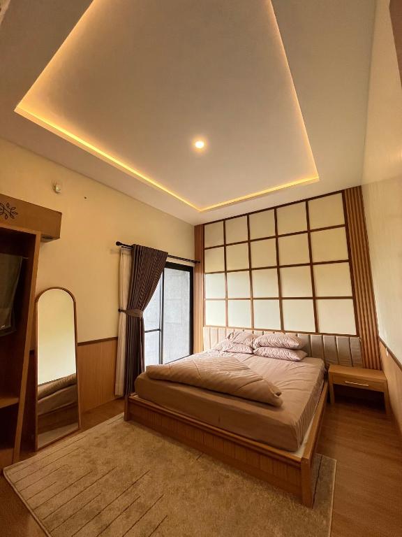 a bedroom with a bed and a large window at Athara Residence in Tlekung