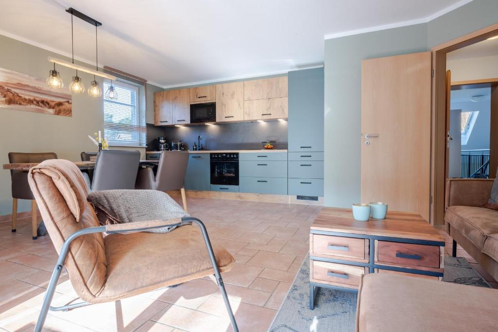 a kitchen and living room with a couch and a table at Witter Barg - Ferienwohnung mit Sauna in Koserow