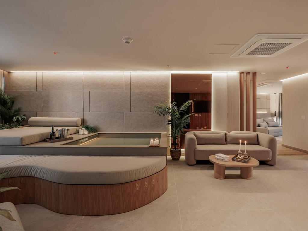 a living room with a bed and a bath tub at Devú in Medellín