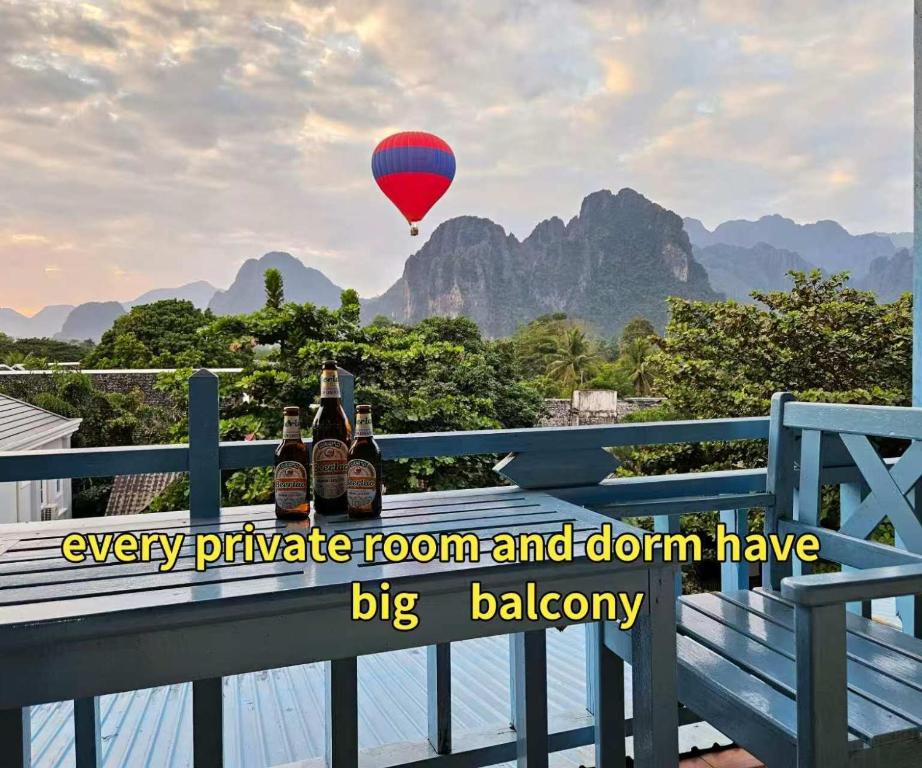 a bunch of bottles of beer on a railing with a hot air balloon at west water hostel in Ban Khouaphan