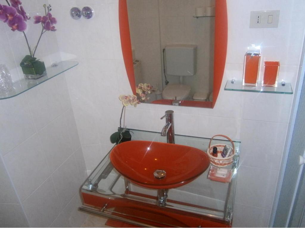 a bathroom with a red sink and a mirror at B&B Ametista in Trieste