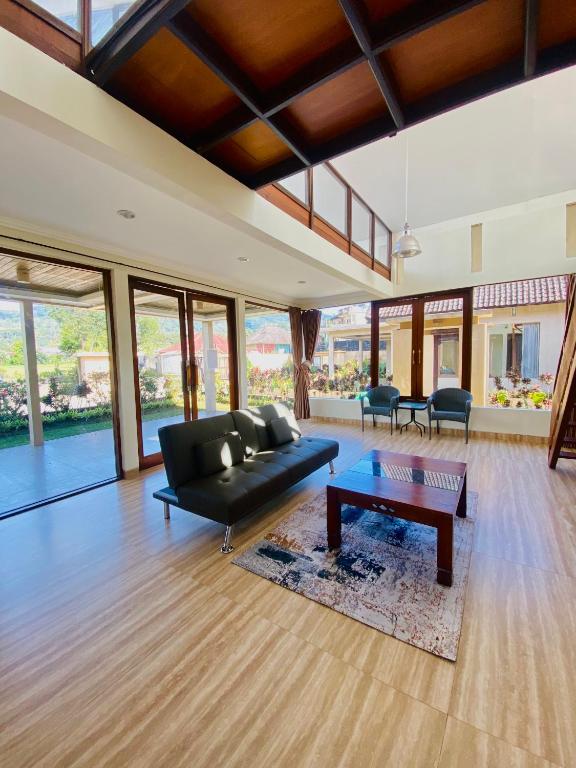 a living room with a black couch and a table at Bedugul Lake View Inn in Bedugul