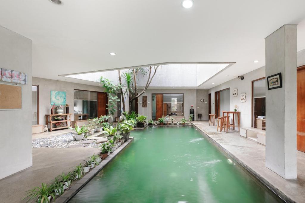 an indoor pool in a building with green water at Urbanview Hotel The Lodge Karawaci in Tangerang
