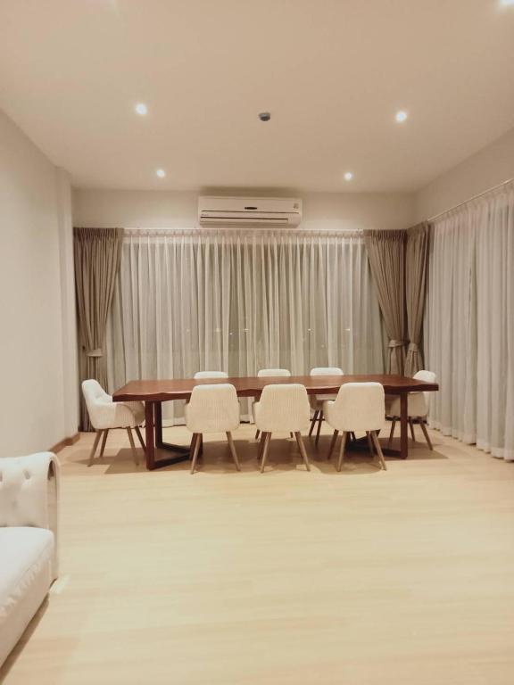 a dining room with a table and white chairs at Patra Phuket Private Residence in Ban Nong Chaeng