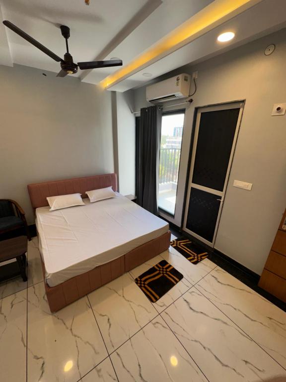 a bedroom with a bed and a large window at Royal kesari in Jhunjhunūn