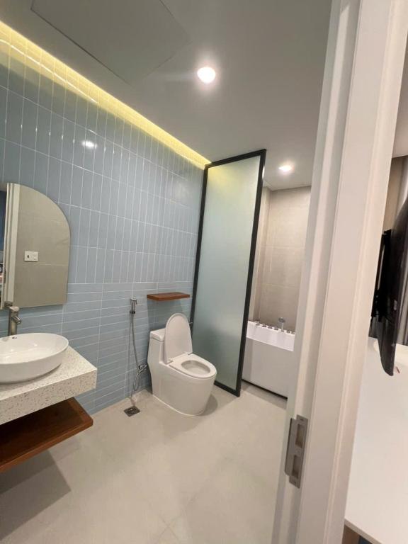 a bathroom with a toilet and a sink and a mirror at Biệt thự Hồ Tràm B SH42 in Xuyên Mộc