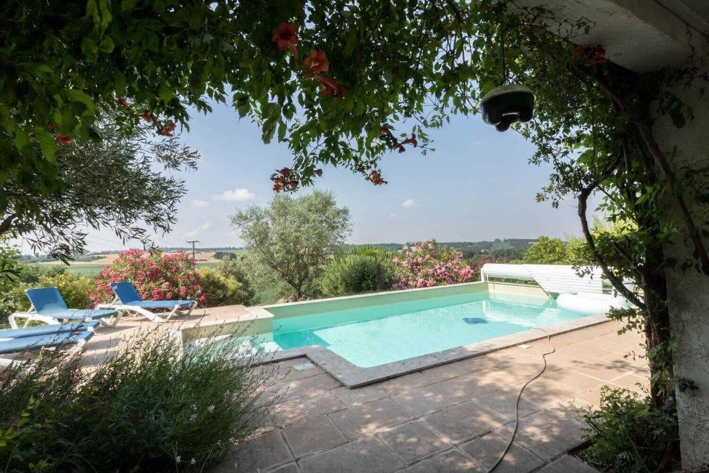 a swimming pool with two chairs and a tree at La marquette in Montrabé