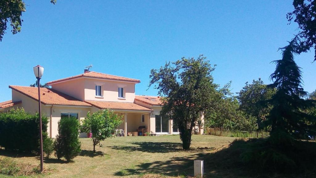 a large white house with trees in the yard at Le pin parasol in Arnac-la-Poste