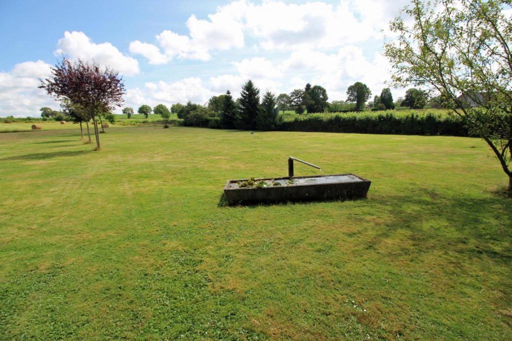 a large field with a tub in the middle of it at Le monteil in Arnac-la-Poste