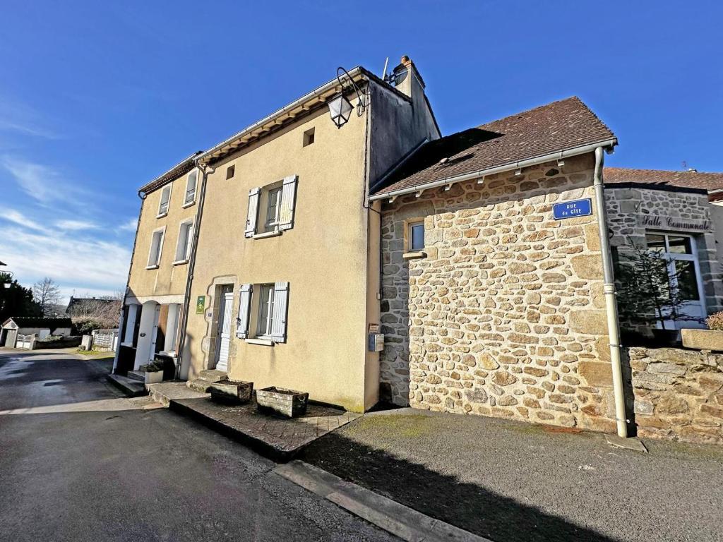 an old brick building sitting on the side of a street at Le gîte communal in Dompierre-les-Églises