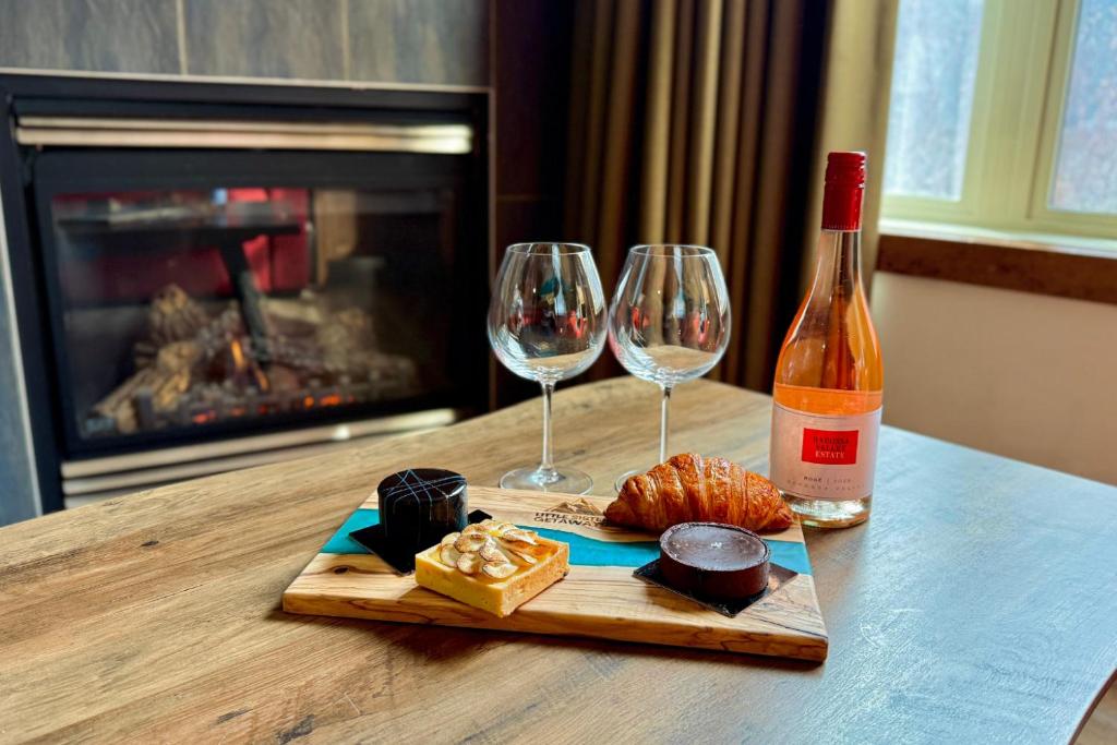a bottle of wine and two wine glasses on a table at Spacious, Pet Friendly, Townhouse Hot Tub Perfect for Families! in Canmore