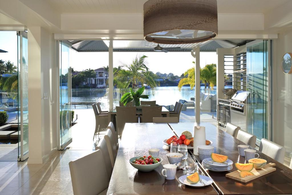 a dining room with a table with food on it at The Peninsula Secret - spacious waterfront & heated Spa in Noosaville