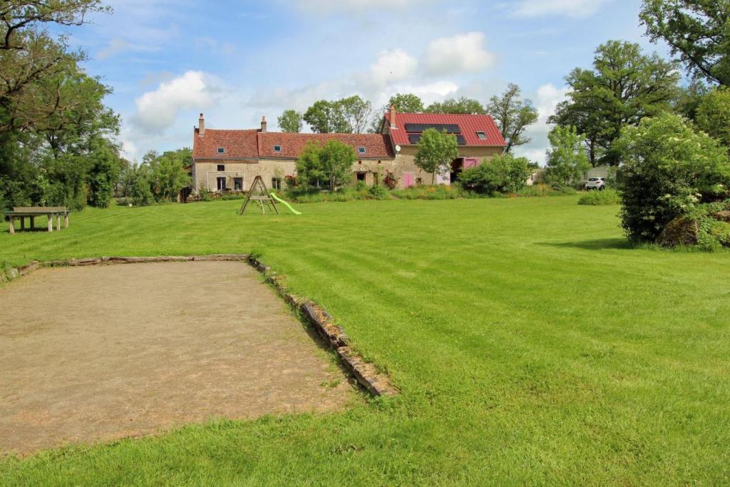 a large field with a large house in the background at Les cheyroux in Saint-Léger-Magnazeix