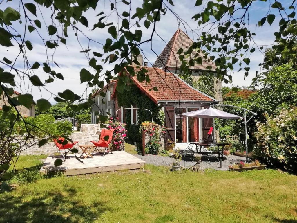 a yard with a house with a playground and chairs at Les séquoias in Javerdat