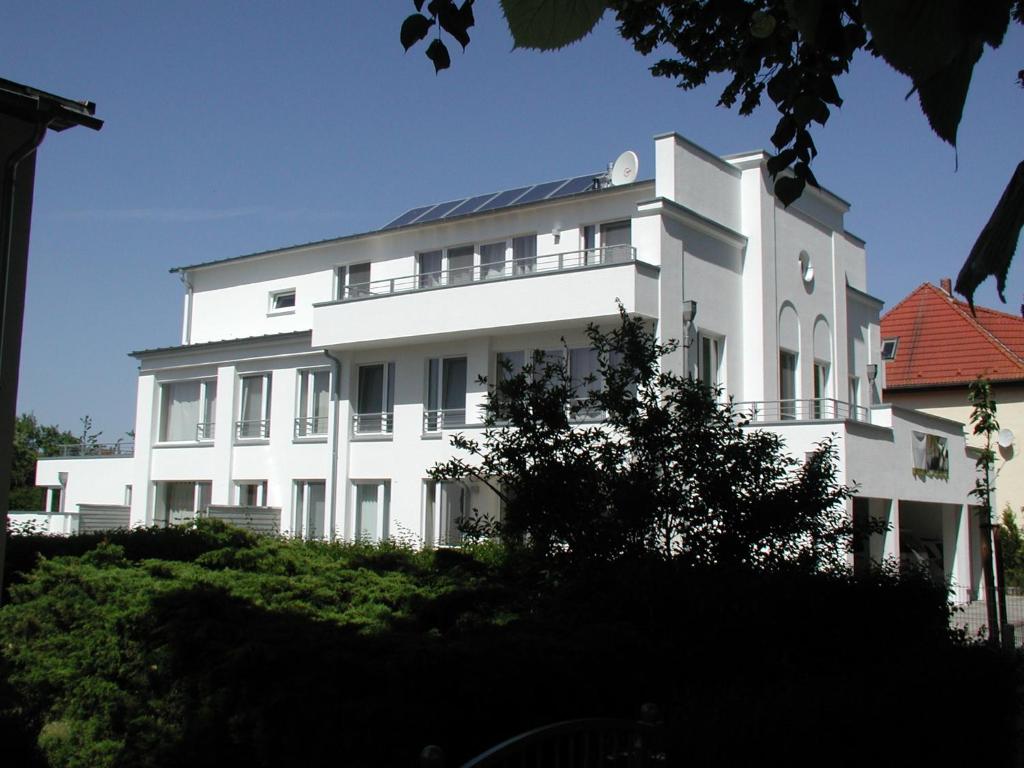 ein weißes Gebäude mit einem Solarium darüber in der Unterkunft Sommerloft Rerik in Rerik