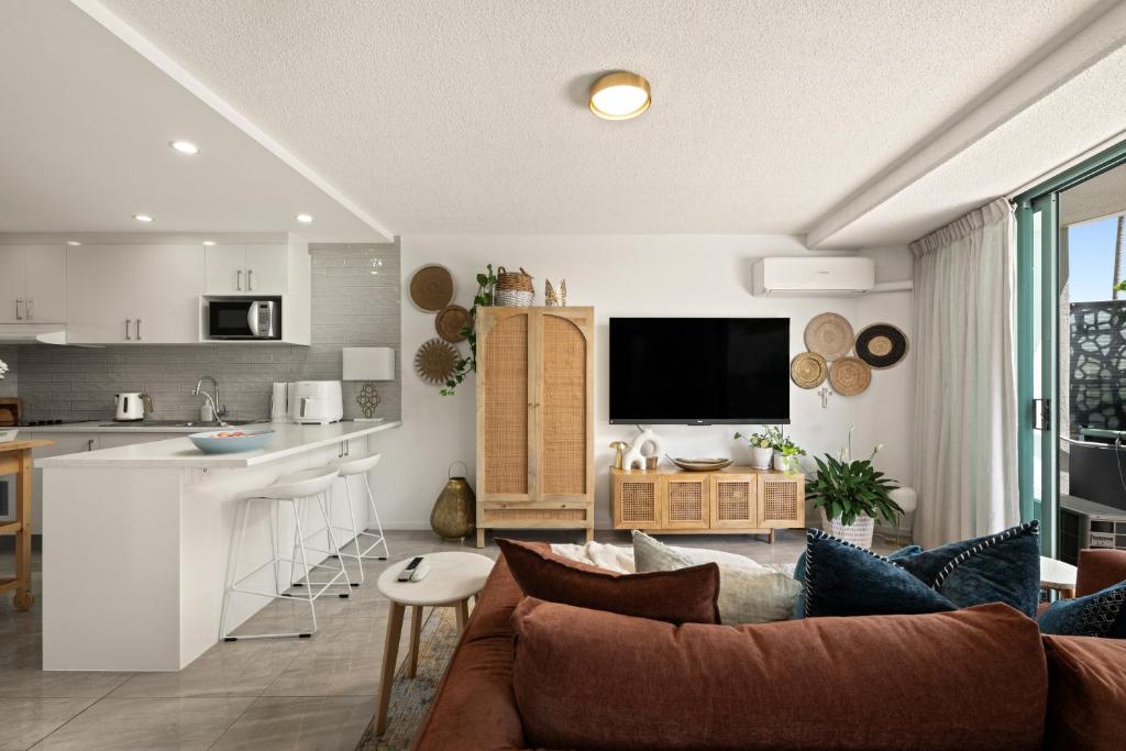 a living room with a couch and a kitchen at Classic Coastal Escape - 1 Bedroom Ocean Views in Maroochydore