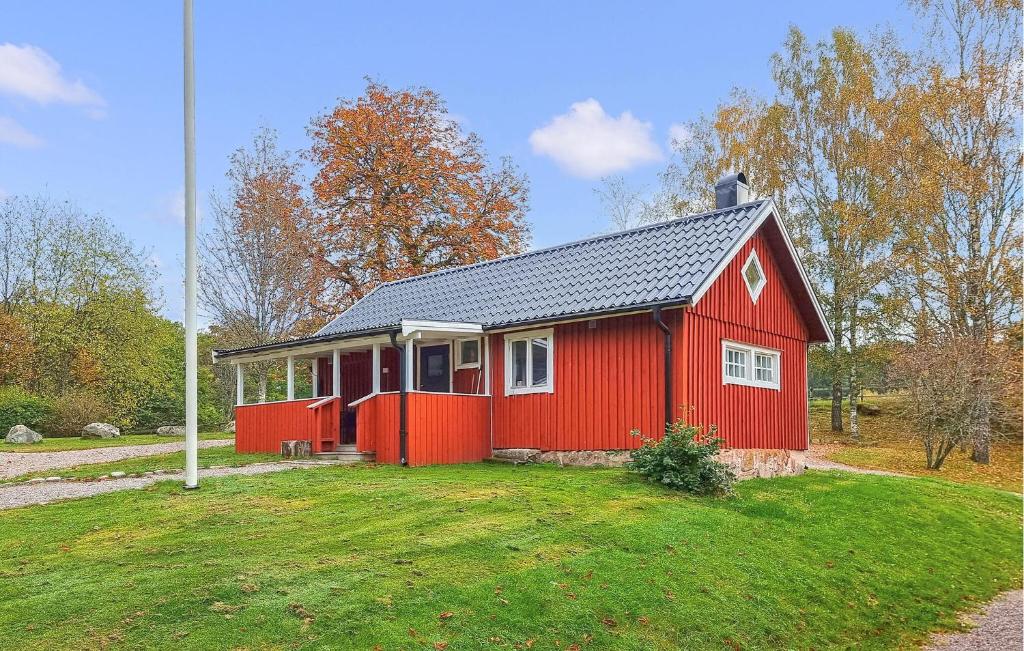 a red house in a field with a yard at 2 Bedroom Nice Home In Örkeljunga in Orkelljunga