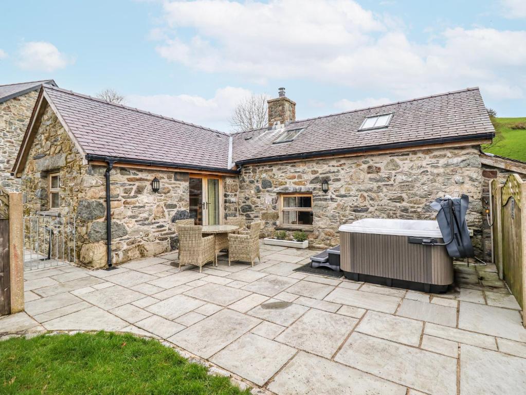 a patio in front of a stone house at Briws in Llangwm