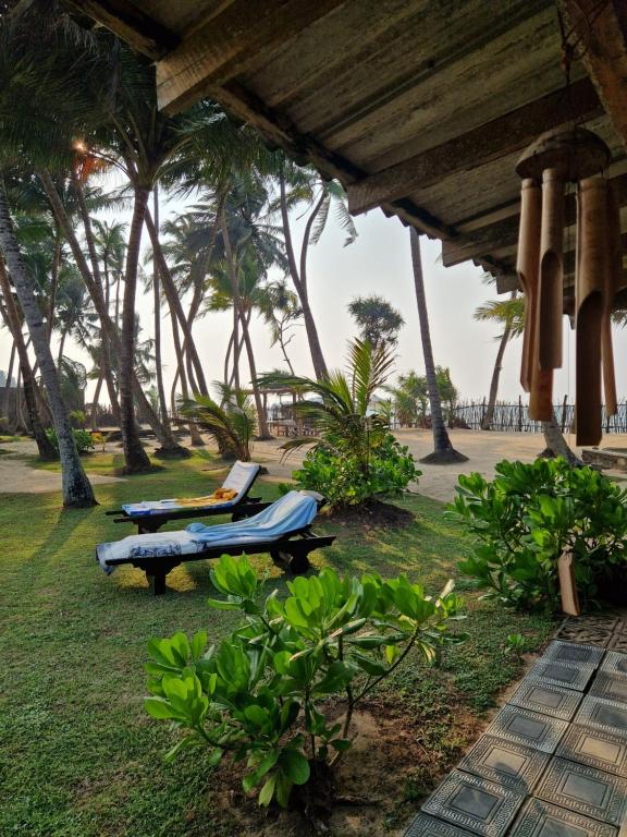 a beach with two lounge chairs and palm trees at CocoVilla Boutique Resort in Beruwala