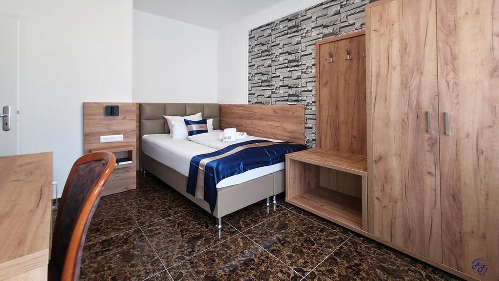 a small bedroom with a bed and a brick wall at Hotel Sofia in Bad Wildungen