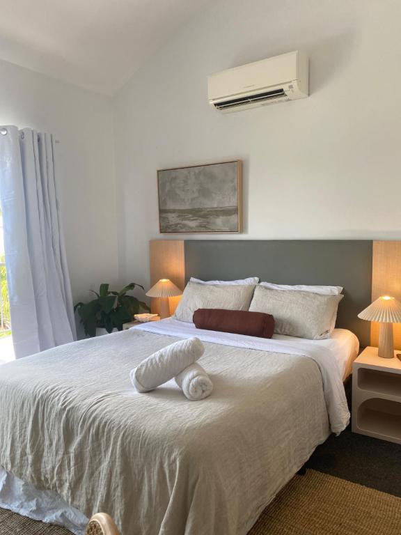 a bedroom with a white bed with a white pillow on it at Corrigans Beach Escape Studio in Batehaven