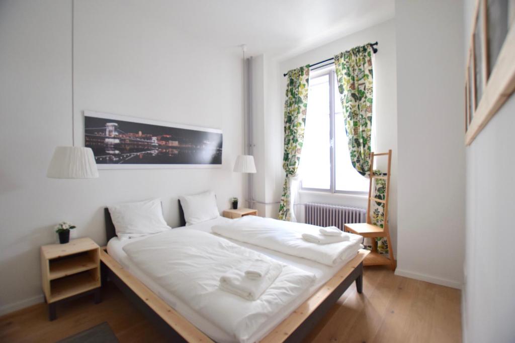 ブダペストにあるLuxury Apartment by Hi5 - Bajcsy Suiteのベッドルーム1室(白いシーツ付きのベッド1台、窓付)