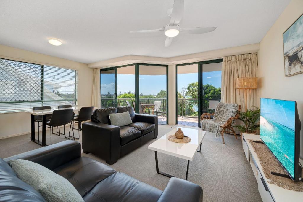 a living room with a couch and a tv at Seacrest Unit 2 Moffat Beach QLD in Caloundra