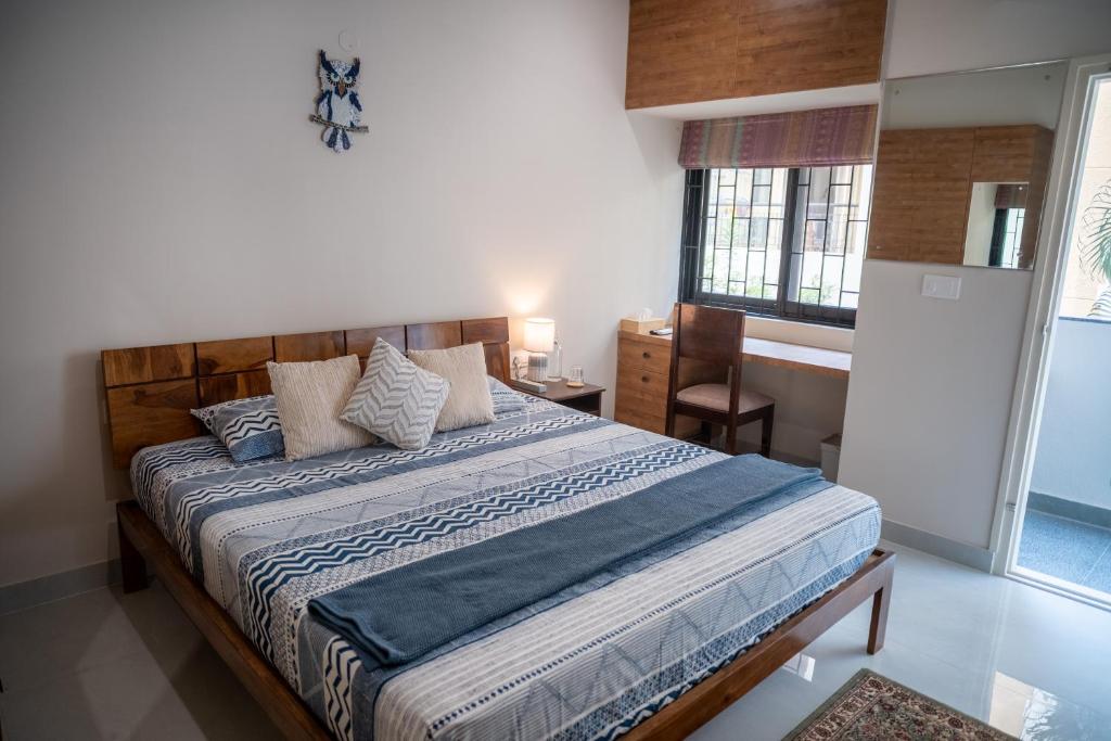 a bedroom with a bed with a blue comforter at Luho Aarambha in Bangalore