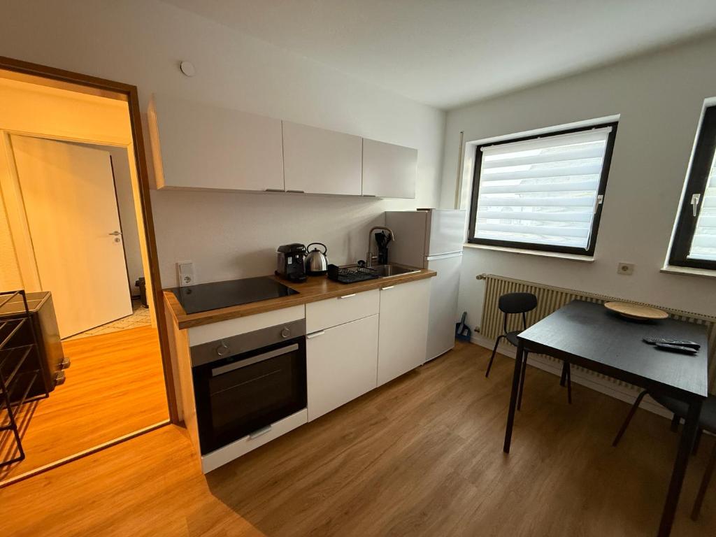 a kitchen with white cabinets and a table and a window at Ferienwohnung LuMa in Rottenacker in Rottenacker