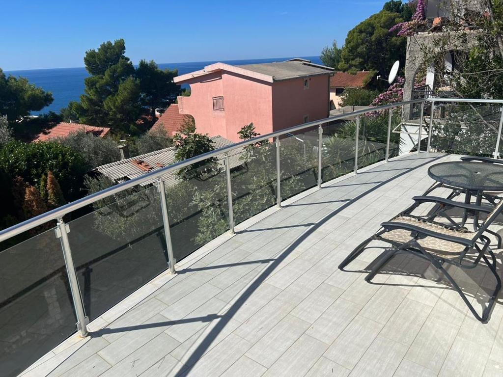 a wooden deck with a table and chairs on a balcony at Bright house in Bar