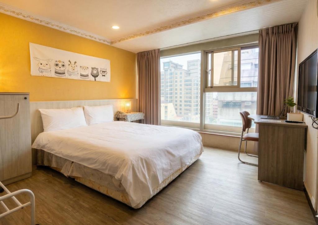 a hotel room with a bed and a large window at Ezstay Station in Kaohsiung