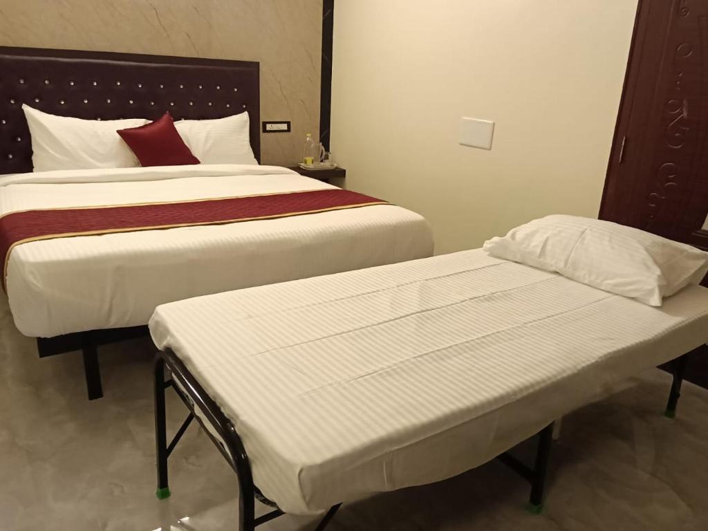 two beds in a hotel room with two mattresses at Tamil Homestay in Thanjāvūr