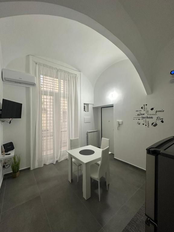 a living room with a white table and a white chair at Dimora del Corso in Caserta