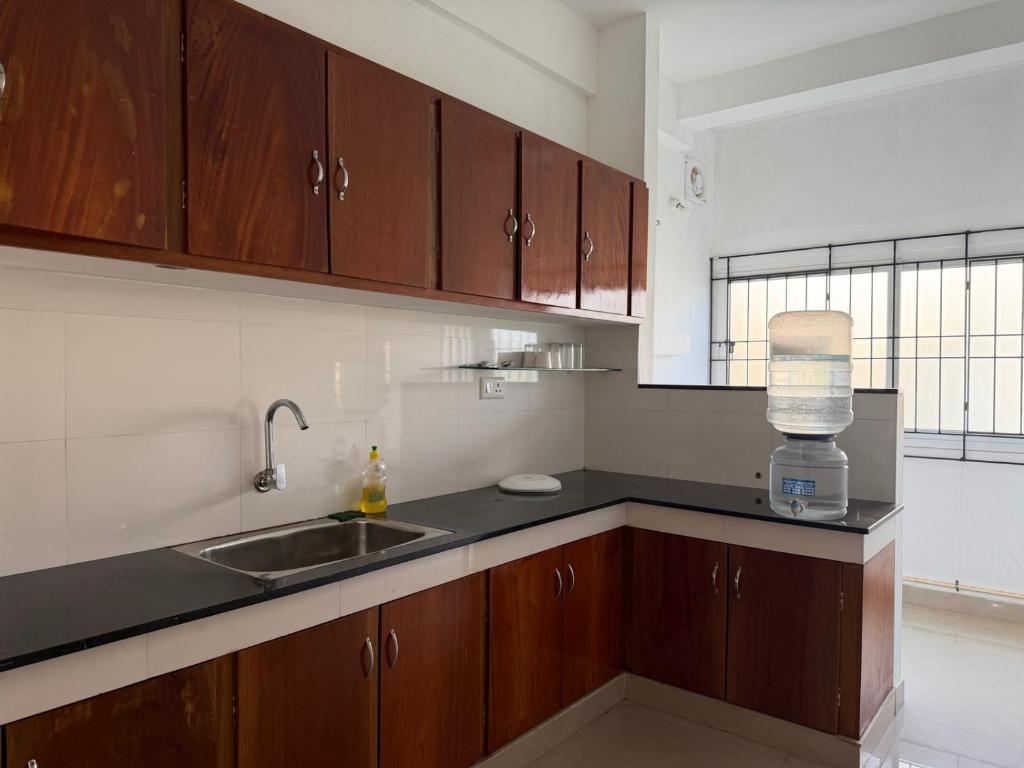 a kitchen with wooden cabinets and a sink and a window at Hotel serenity in Cochin