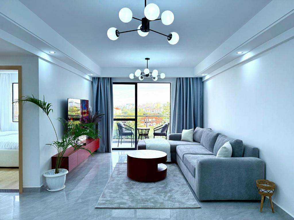 a living room with a couch and a table at Pearl Luxe Homes at Orchid Residency - Spacious 2BR in Westlands With Pool, Gym, Rooftop views & breakfast café in Nairobi