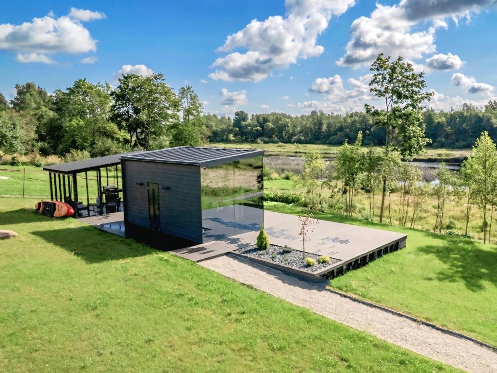 a glass house in a field with a garden at Pulli Country Club - Private Sauna & River View in Pärnu
