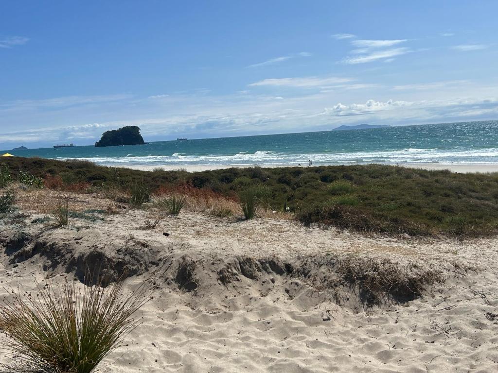 a sandy beach with the ocean in the background at Stunning Mount beachside location in Mount Maunganui