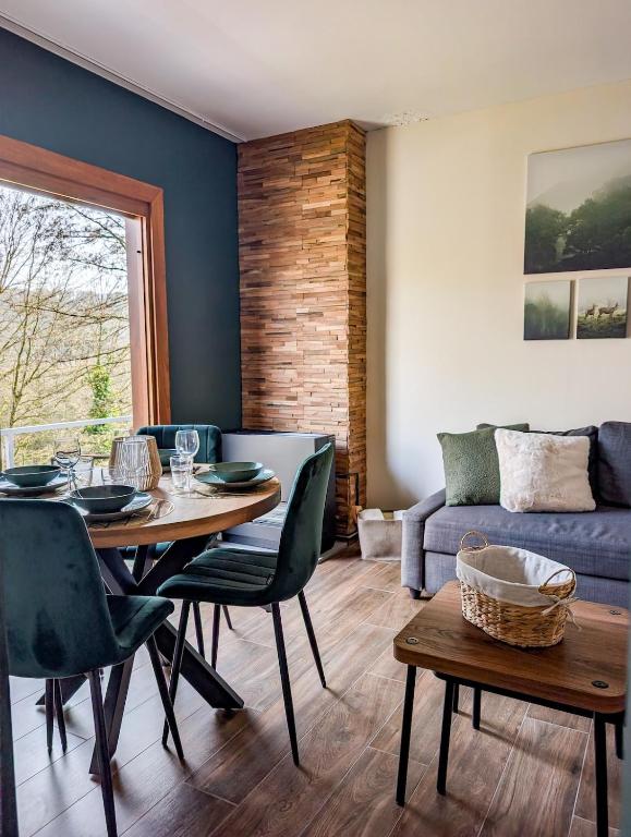 a living room with a table and chairs and a couch at L'émeraude Waulsort in Waulsort