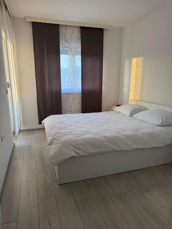 a bedroom with a large bed and a window at White Horizon Apartment in Teslić
