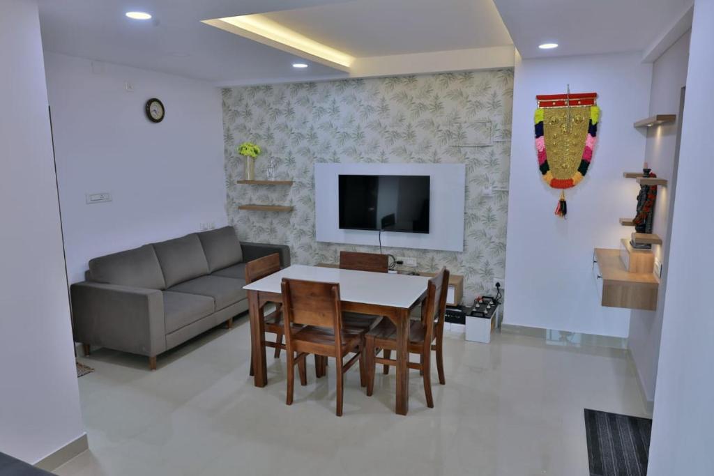 a living room with a table and chairs and a couch at Vaiga Heavens - 1 BHK Apartment, 500 m to temple in Guruvāyūr