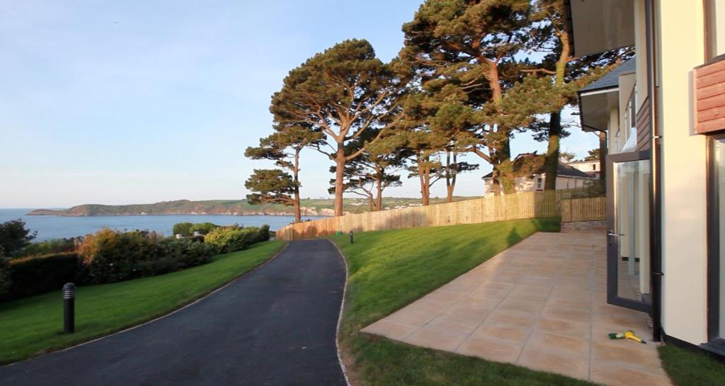 a driveway to a house with a view of the water at Shorthorn Apartment, 53a Sea Road in Carlyon Bay