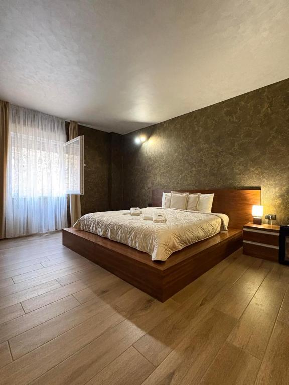 ein Schlafzimmer mit einem großen Bett und einem Fenster in der Unterkunft Monogramlux in Inđija